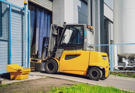 Photo for Forklift loader near big industrial storage warehouse - Royalty Free Image