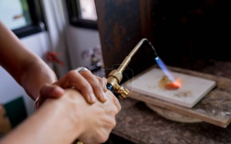 Téléchargez les photos : Professeur bijoutier et étudiant utilisant un brûleur en atelier. - en image libre de droit