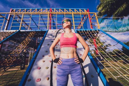 Photo for Athletic young woman working out and climbing at the artificial rock in training camp - Royalty Free Image