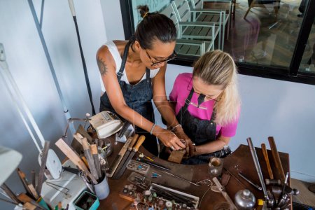 Téléchargez les photos : Professeur bijoutier et étudiant font des bijoux en atelier. - en image libre de droit