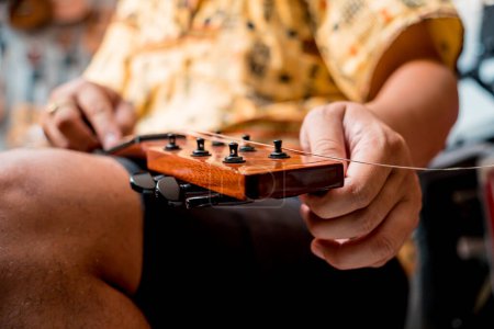 Foto de Joven músico cambiando cuerdas en una guitarra clásica en una tienda de guitarra. - Imagen libre de derechos