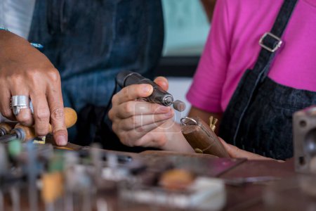 Téléchargez les photos : Professeur bijoutier et étudiant font des bijoux en atelier. - en image libre de droit