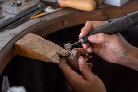Téléchargez les photos : Jeune faemale bijoutier polissage bijoux en atelier. - en image libre de droit