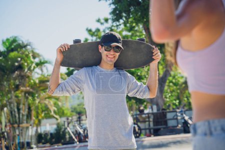 Photo for Young happy couple with skateboards enjoy longboarding at the skatepark. - Royalty Free Image