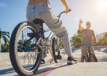 Téléchargez les photos : Jeune couple heureux profiter BMX équitation au skatepark. - en image libre de droit