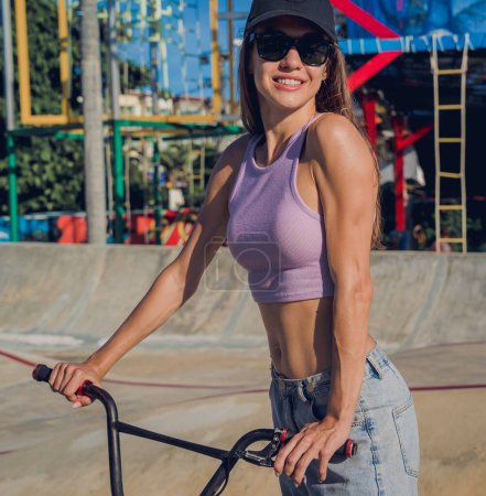 Téléchargez les photos : Joyeux jeune femme profiter BMX équitation au skatepark. - en image libre de droit