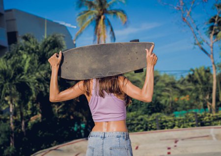 Téléchargez les photos : Joyeux jeune femme avec skateboard profiter du longboard au skatepark. - en image libre de droit
