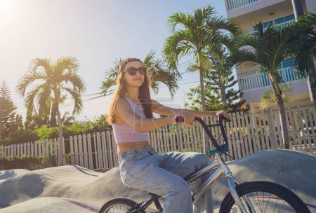 Photo for Happy young woman enjoy BMX riding at the skatepark. - Royalty Free Image