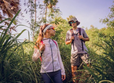 Téléchargez les photos : Joyeux jeune couple voyageant dans la forêt de jungle près de l'océan. - en image libre de droit