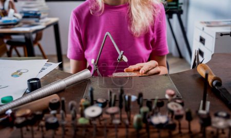 Téléchargez les photos : Jeune bijoutière fabriquant des bijoux en atelier. - en image libre de droit