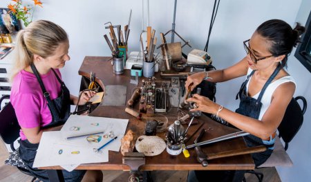Photo for Teacher jeweler and student make jewelry in workshop. - Royalty Free Image