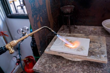 Foto de Joyero usando un quemador para dar forma a una pieza en un taller. - Imagen libre de derechos