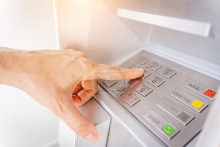 Téléchargez les photos : Jeune femme utilisant la carte pour retirer l'argent dans le guichet automatique. - en image libre de droit