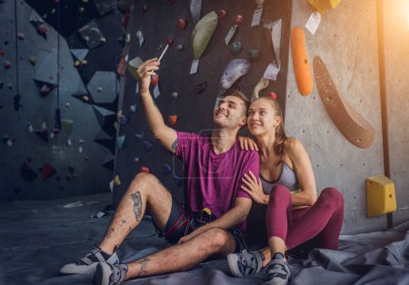 Foto de Un fuerte par de escaladores contra una pared artificial con pintorescos agarres y cuerdas - Imagen libre de derechos