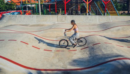 Photo for Happy young woman enjoy BMX riding at the skatepark. - Royalty Free Image