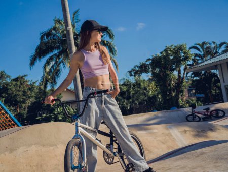 Foto de Feliz joven mujer disfrutar de BMX montar en el skatepark. - Imagen libre de derechos