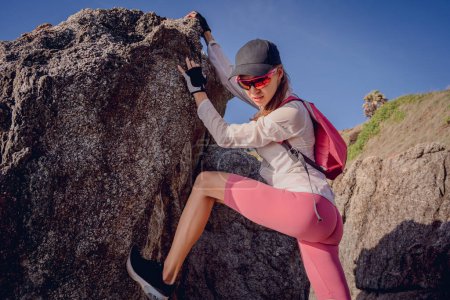 Téléchargez les photos : Jeune femme monte au sommet dans les montagnes près de l'océan. - en image libre de droit