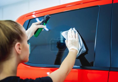 Photo for Car detailing worker cleaning and polishing car with microfiber cloth and vacuum - Royalty Free Image