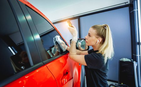 Téléchargez les photos : Voiture détaillant travailleur nettoyage et polissage voiture avec chiffon en microfibre et aspirateur - en image libre de droit