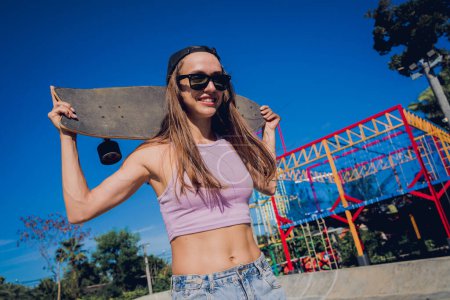 Photo for Happy young woman with skateboard enjoy longboarding at the skatepark. - Royalty Free Image