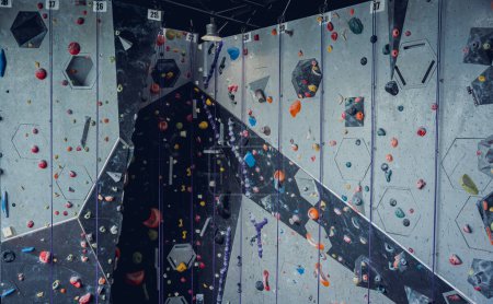 Photo for Artificial climbing wall with colorful grips and ropes. - Royalty Free Image
