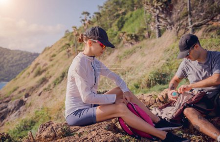 Téléchargez les photos : Heureux jeune couple se détendre après les montées au sommet des montagnes près de l'océan. - en image libre de droit