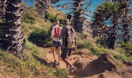 Téléchargez les photos : Jeune couple voyageant dans la forêt de jungle près de l'océan. - en image libre de droit