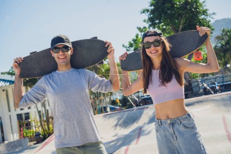 Foto de Joven pareja feliz con monopatines disfrutan del longboard en el skatepark. - Imagen libre de derechos