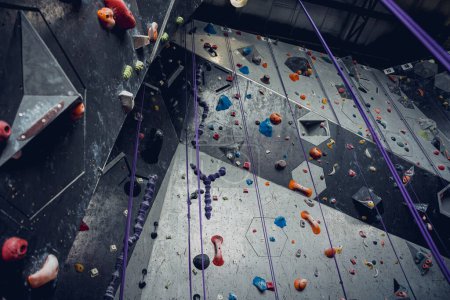 Foto de Pared de escalada artificial con pintorescos agarres y cuerdas. - Imagen libre de derechos