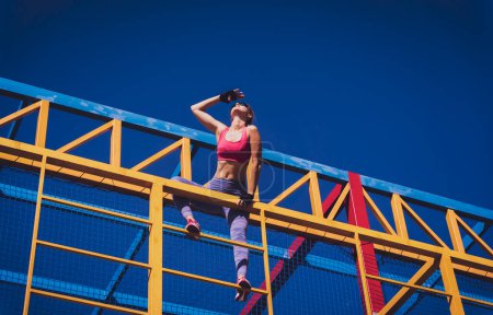 Téléchargez les photos : Jeune femme sportive faisant de l'exercice et de l'escalade au camp d'entraînement - en image libre de droit