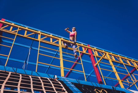 Photo for Athletic young woman working out and climbing at the training camp - Royalty Free Image