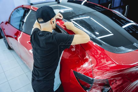 Photo for The process of installing protective film on the new red car - Royalty Free Image