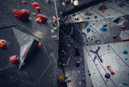 Photo for Artificial climbing wall with colorful grips and ropes. - Royalty Free Image