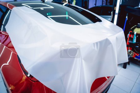 Foto de El proceso de instalación de la película protectora en el nuevo coche rojo - Imagen libre de derechos