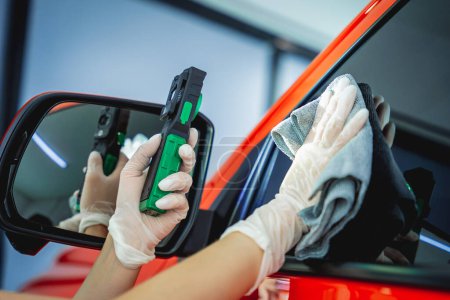 Foto de Car detallando el coche de limpieza y pulido del trabajador con tela de microfibra y vacío - Imagen libre de derechos