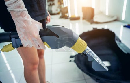 Photo for Young woman cleaning the car details with a washing vacuum cleaner. - Royalty Free Image