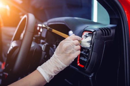 Foto de Mujer joven limpiando el interior del coche con un cepillo especial con espuma. - Imagen libre de derechos