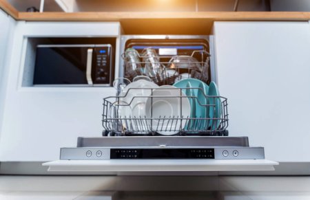 Photo for The white kitchen and opened dishwasher with clean dishes. - Royalty Free Image