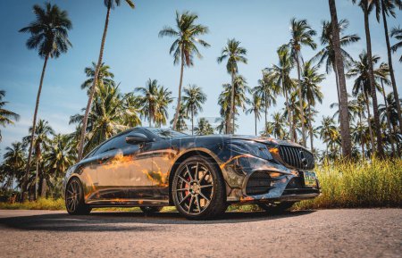 Foto de PHUKET, TAILANDIA - 24 DE DICIEMBRE DE 2023: Hermosa Mercedes AMG E53 brillante contra de la naturaleza con palmas. - Imagen libre de derechos