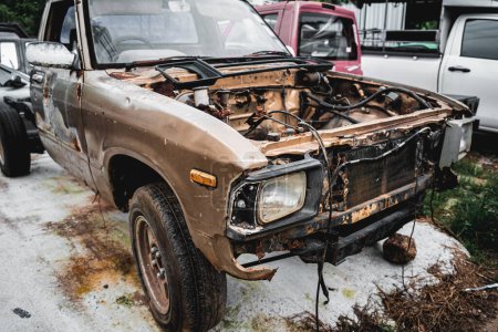 Photo for Rusty abandoned car at a big car scrapyard. - Royalty Free Image