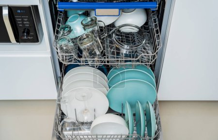 Téléchargez les photos : La cuisine blanche et lave-vaisselle ouvert avec vaisselle propre. - en image libre de droit