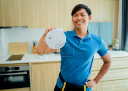 Photo for Technician installing fire safety detector in a modern apartment. - Royalty Free Image