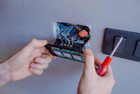 Photo for Technician installing sensor light switch at modern villa. - Royalty Free Image