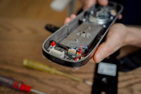 Téléchargez les photos : Un technicien assemble et installe une serrure électronique intelligente pour la protection de la maison. - en image libre de droit