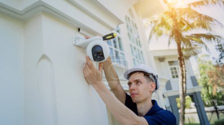 Photo for A technician installs a CCTV camera on the facade of a residential building - Royalty Free Image
