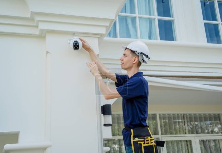 Photo for A technician installs a CCTV camera on the facade of a residential building - Royalty Free Image