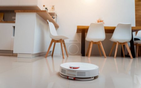 Foto de Una aspiradora robot en casa moviéndose hacia la estación de carga - Imagen libre de derechos