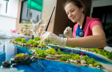 The process of making the art decor of epoxy resin, natural stones and moss.