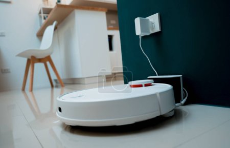 Téléchargez les photos : Un robot aspirateur à la maison se déplaçant vers la station de charge - en image libre de droit