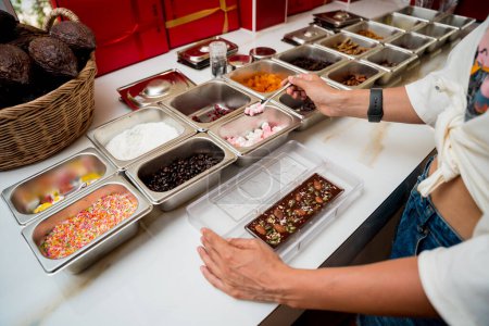 Téléchargez les photos : Jeune femme dans l'atelier lors d'une leçon sur la fabrication artisanale de chocolats et de bonbons. - en image libre de droit